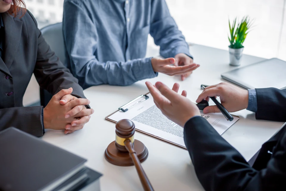Un expert-comptable ou un professionnel des services aux entreprises en costume assis à un bureau avec des documents fiscaux, des dossiers d'entreprise et un ordinateur, en train de consulter un client entrepreneur ou artisan sur des documents relatifs à la création ou gestion d'une entreprise. La scène doit montrer une relation client bienveillante et personnalisée, dans un cadre professionnel moderne et rassurant, avec une atmosphère de confiance et d'accompagnement spécialisé.