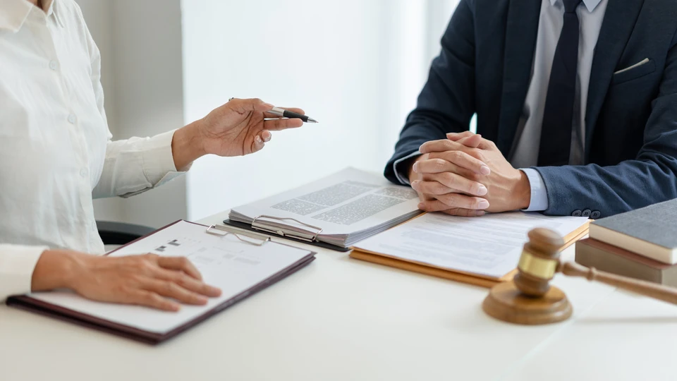 Bureau d'avocat avec professionnel en costume sombre rédigeant des documents juridiques